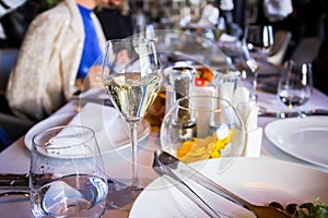 Glassware, glasses for white wine on a table in a restaurant. Banquet, cutlery, table setting. photo