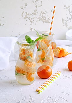 Glassware with refreshing citrus mandarine mint fruits cocktail, detox water