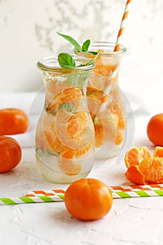 Glassware with refreshing citrus mandarine mint fruits cocktail, detox water