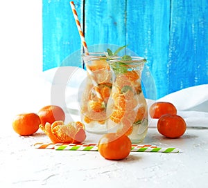 Glassware with refreshing citrus mandarine mint fruits cocktail, detox water