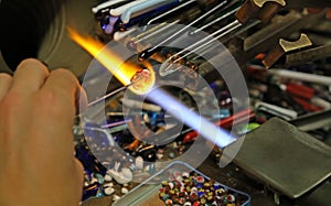 glassworker works with hot flame in the workshop in italy