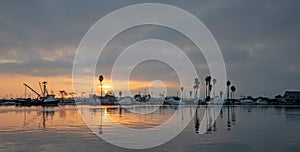 Glassy water and sunrise pink sky over Channel Islands harbor in Oxnard California United States