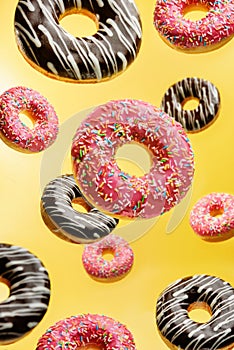Glazed donuts levitating on a yellow background