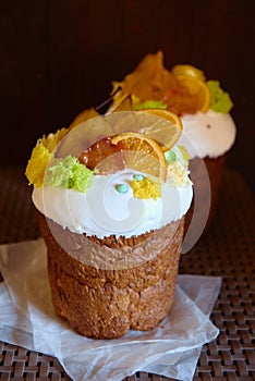 Glazed easter cake decorated with dried orange and pear slices on dark background, copy space. Happy Easter holidays. Kulich.