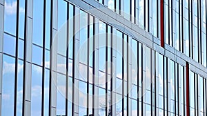 The glazed facade of an office building with reflected sky.