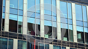 The glazed facade of an office building with reflected sky.