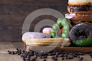 Glazed mini gluten free donuts with coffee candies on wooden background. Party food concept with copy space.