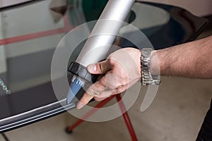 Glazier applying rubber sealing to windscreen