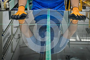 The glazier breaks the panes of glass on a professional cutting table