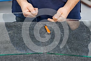 The glazier cuts the glass with a professional tool