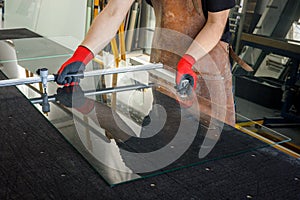 The glazier cuts a large sheet of glass. Glass workshop, Specialist work tools