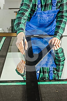 A glazier cuts thick glass on a specialized table, Concept, Glass work, Vertical photo