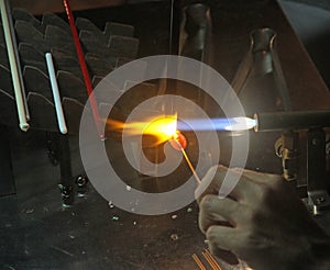 Glazier with gas torch lit while blending a piece of glass 2