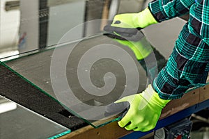 The glazier puts the glass on the cutting table in the glass factory, Trimming glass panels