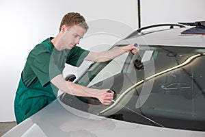 Glazier removing windshield