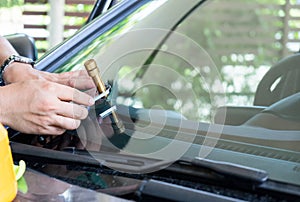 Glazier using tools repair to fix crack windshield