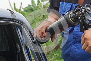 Glazier using tools repairing to fix crack broken windshield.