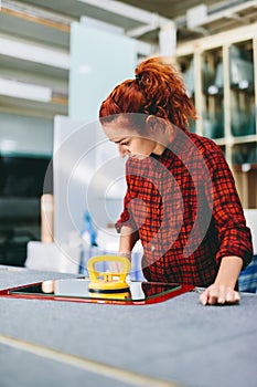 Glazier woman worker holding a glass pane with suction cups in workshop