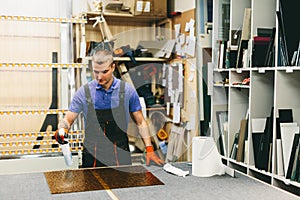 Glazier worker cleaning glass in workshop. Industry