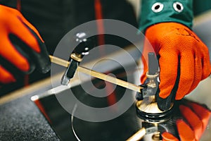 Glazier worker cutting glass with compass glass cutter in a workshop