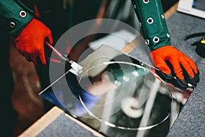 Glazier worker cutting glass with compass glass cutter in a workshop