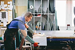 Glazier worker cutting glass with fire in a workshop