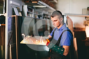 Glazier worker cutting glass with fire in a workshop