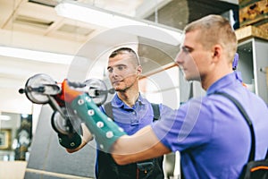 Glazier worker holding a big mirror glass pane in workshop.