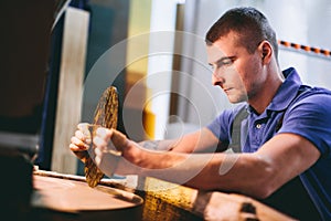 Glazier worker polishing glass in workshop. Industry