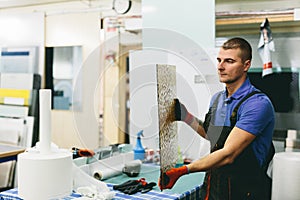 Glazier worker preparing glass in workshop. Industry