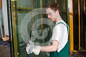 Glazier in workshop handling glass