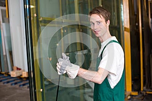 Glazier in workshop handling glass