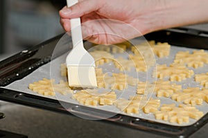 Glazing cookies on backing paper in a tray