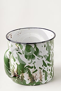 A gleaming cup with white and green patterns, now used to savor beverages with a vintage classic touch.