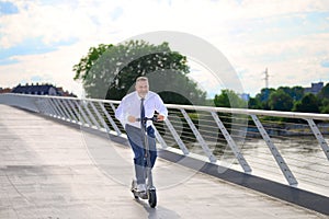 Gleeful businessman enjoying his ride on an electric scooter