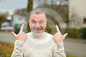 Gleeful elated man grinning at the camera while gesturing