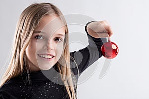 Gleeful grin as girl exhibits Christmas ornament