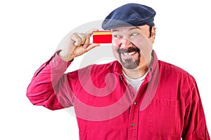 Gleeful man eyeing his credit card with a smile