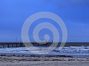 Glenelg jetty and beach under the storm with thick cloud and blue tone