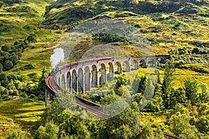 Glenfinnan Railway Viaduct in Scotland with a steam train