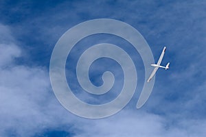 A glider flying across the blue sky