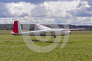 The glider is passing at low altitude over the strip