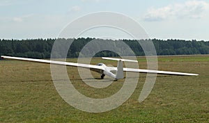 Glider plane standing on grass airport runway, at Pociunu airport, Lithuania