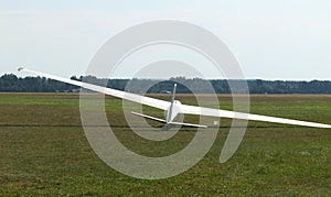 Glider plane standing on grass airport runway, at Pociunu airport, Lithuania