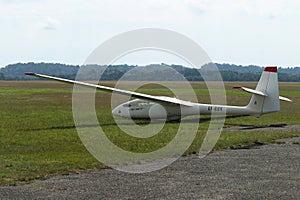 Glider plane standing on grass airport runway, at Pociunu airport, Lithuania