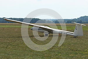 Glider plane standing on grass airport runway, at Pociunu airport, Lithuania