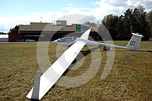 Glider plane standing on grass airport runway, at Pociunu airport, Lithuania