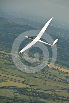 Glider, sailplane flying over countryside.