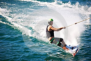 Gliding through the wake. A wakeboarder cutting out on his heelside egde - copyspace.