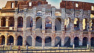 Glimpse of Colosseum in a summer evening with tourists enjoying the beauties of Rome